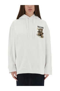 Moschino women’s white hoodie with brown teddy bear graphic on the chest made from soft cotton material