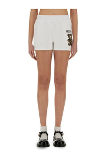 Moschino women’s white cotton shorts with an embroidered teddy bear logo on the left leg