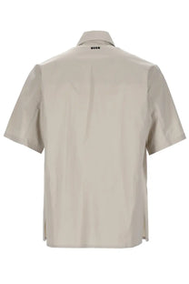 Beige short-sleeved button-up cotton shirt with subtle collar and minimalist branding at the neckline by MSGM men