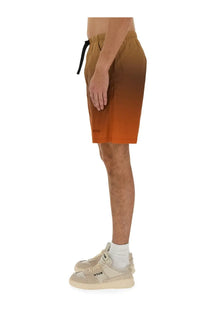 Msgm men’s cotton bermuda shorts featuring tan to orange gradient swim trunks with black drawstring waistband