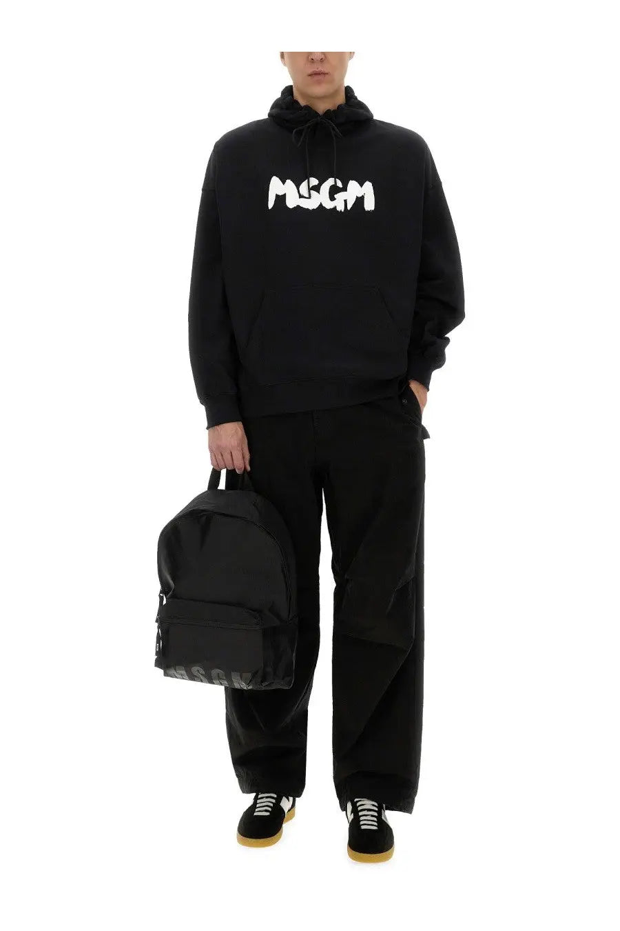 Black msgm backpack with white logo on front and side made of durable fabric paired with men’s black hoodie