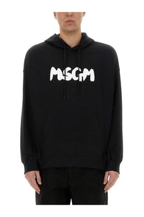 Black msgm men’s hoodie featuring bold white graffiti-style lettering on the chest in cotton material