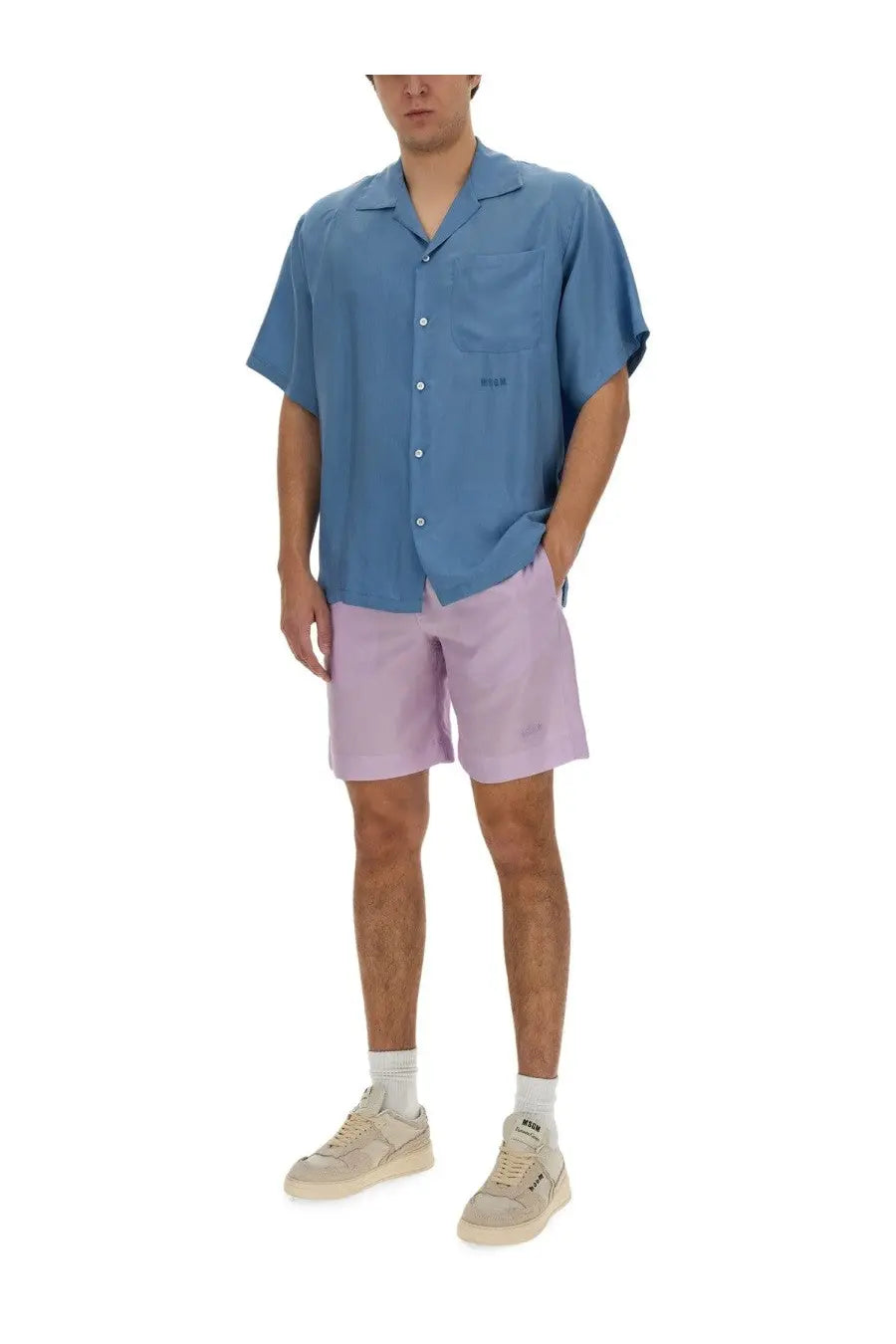 A man wearing MSGM men’s short purple lavender shorts paired with a light blue short-sleeved button-up shirt