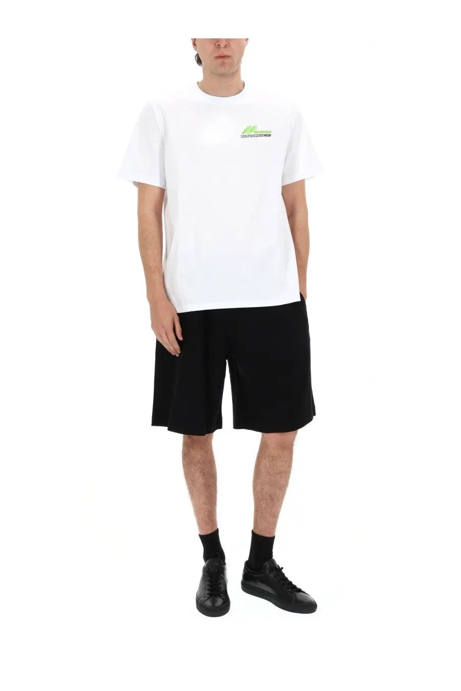 White short-sleeved t-shirt with small green and black logo on left chest paired with msgm black men’s shorts