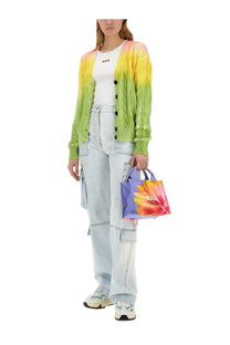 Vibrant tie-dye mini tote bag with purple handles and bold floral print paired with msgm women’s blue denim cargo pants