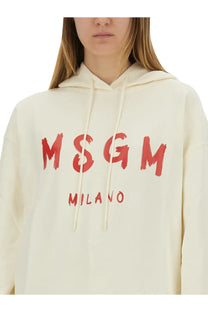 Cream-colored MSGM women’s sweatshirt with bold red brushstroke lettering and milano print on the front