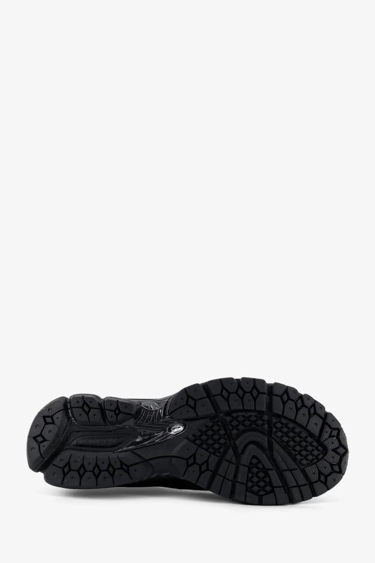 Black rubber sole of new balance men’s gore tex sneakers with textured geometric tread pattern and subtle branding details