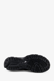 Black rubber sole of new balance men’s gore tex sneakers with textured geometric tread pattern and subtle branding details