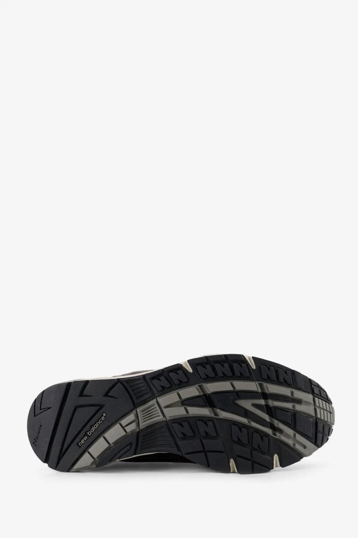 Back side of new balance men’s brown leather sneakers showing black and gray rubber sole with textured tread pattern