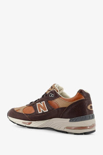 New Balance men’s leather sneakers brown with tan accents and visible air cushioning unit in the sole