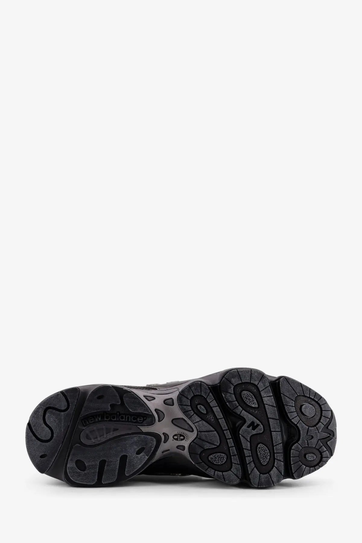 New Balance men’s low top mesh sneakers in black with a textured rubber sole and intricate tread pattern