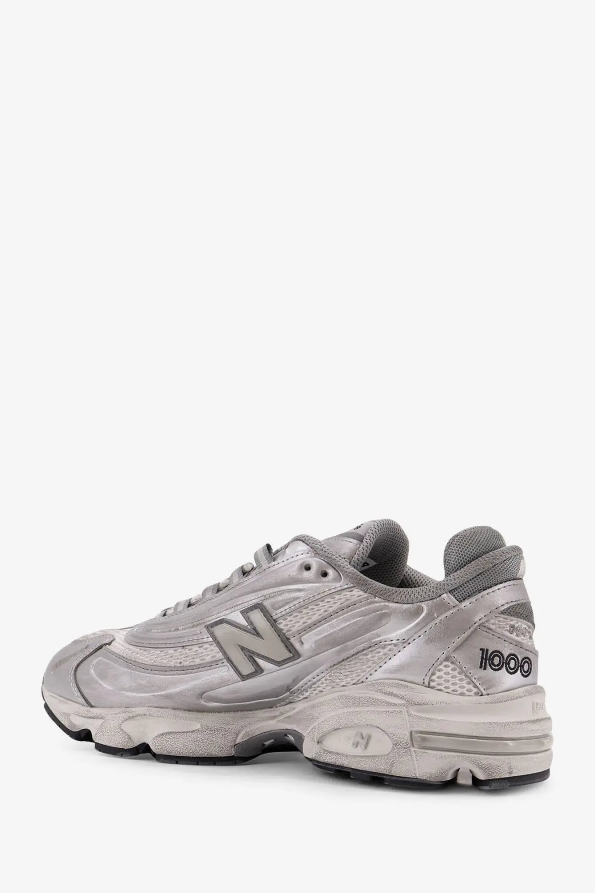 New Balance men’s low top silver sneaker with distressed finish and mesh synthetic overlays