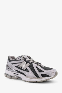 New balance men’s low top mesh sneakers in gray and black with synthetic overlays and silver n logo on the side