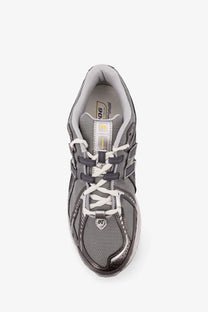 New Balance men’s mesh sneakers grey showing the back with gray upper white laces and metallic silver heel tab