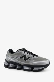 New balance men’s mesh sneakers grey featuring silver and black mesh upper and distinctive air-cushioned sole