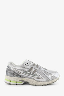 New Balance men’s mesh sneakers in silver and white with gray branding and lime green midsole