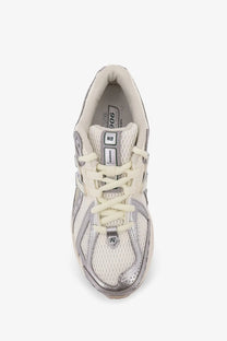 Cream-colored new balance 906 men’s mesh sneakers with metallic silver accents and breathable mesh material