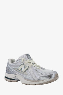 New Balance men’s mesh sneakers silver featuring white and silver running shoe with mesh upper and rubber sole