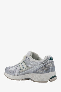 New balance men’s mesh sneakers in white and silver with mesh upper, reflective accents, and teal heel detailing