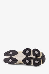 Cream-colored new balance men’s mesh and suede sneaker sole with black rubber diamond tread and speckled texture