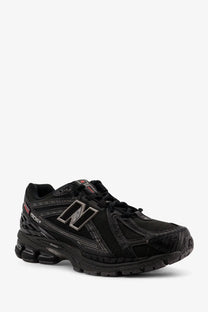 New balance men’s black nylon sneakers with silver logo and red accents designed as 1506v2 running shoes