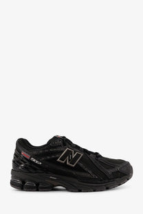 New Balance men’s nylon sneakers black featuring sleek black 1906r running shoe with minimalist design and gray n logo accents
