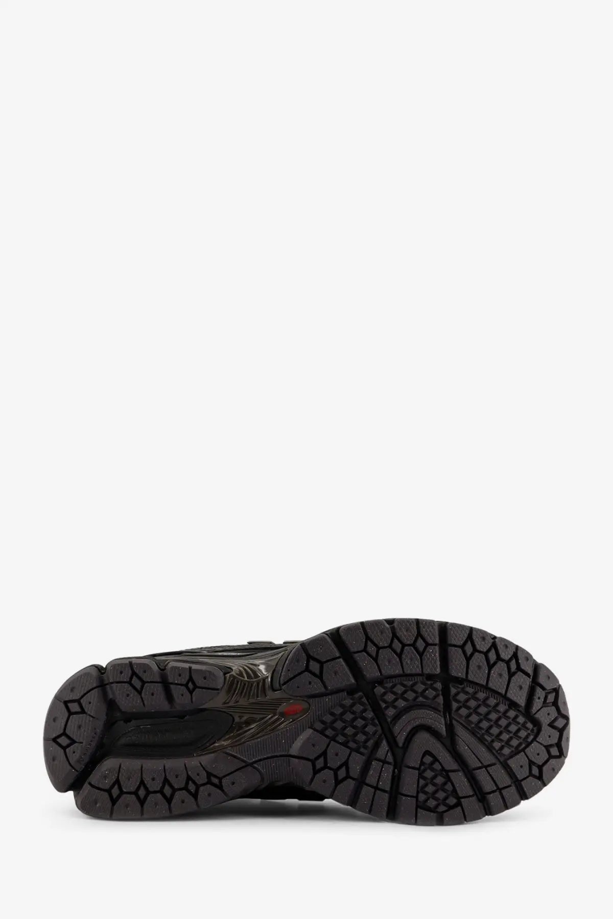 New balance men’s black nylon sneakers featuring a black rubber sole with a textured geometric tread and translucent sections