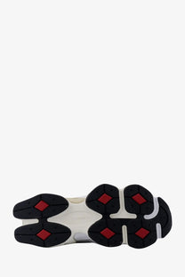 White and black rubber sole with red diamond accents on new balance men’s grey mesh and suede sneakers