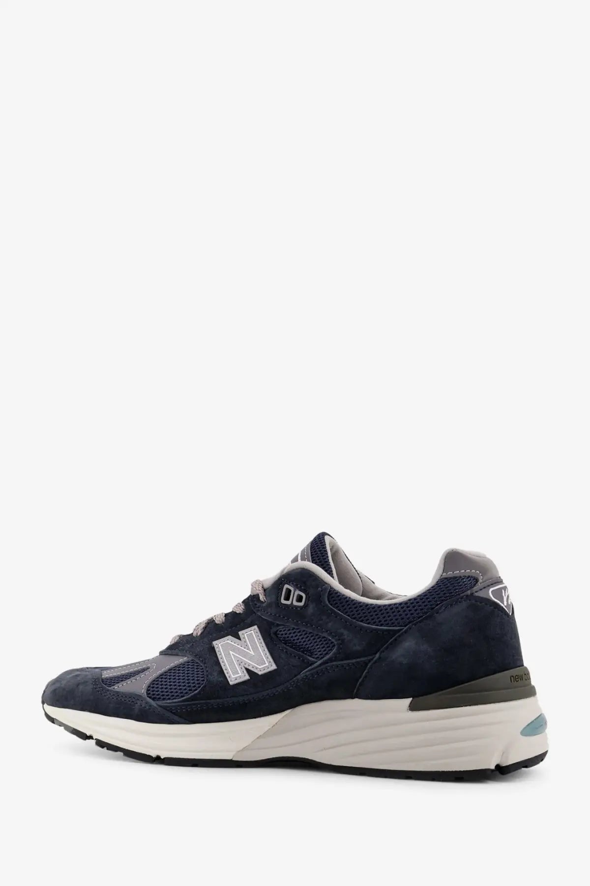 New Balance men’s suede low top sneakers in navy blue with mesh detailing white midsole and gray accents