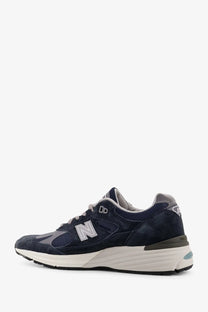 New Balance men’s suede low top sneakers in navy blue with mesh detailing white midsole and gray accents