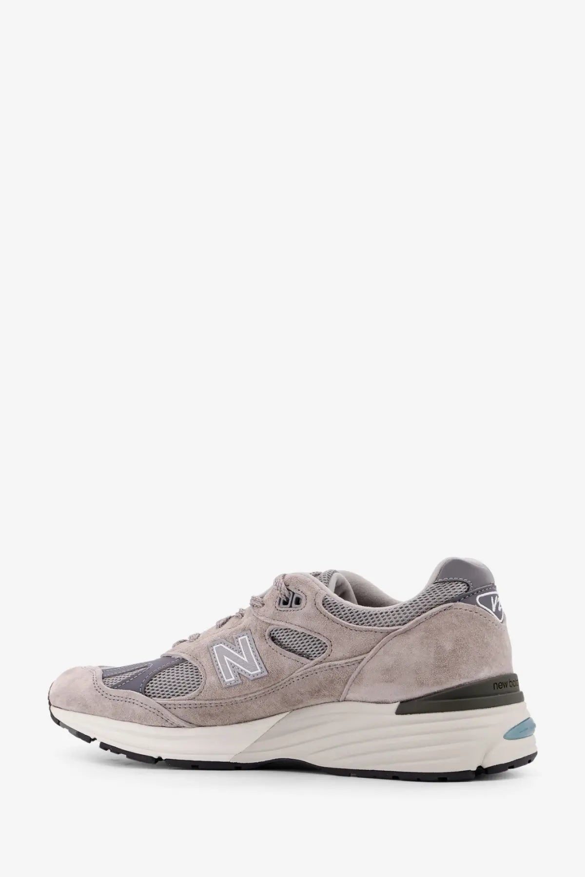 New balance men’s suede and mesh running sneaker in grey with white midsole and black outsole viewed from the back
