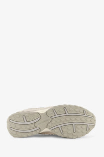 Beige rubber sole with textured tread and new balance logo on green suede and mesh men’s sneakers