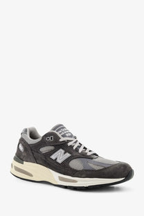 New balance men’s grey sneaker made of dark gray suede and mesh with cream-colored midsole