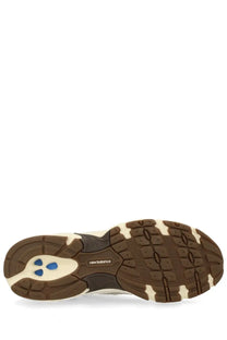 New balance unisex sneaker beige with brown and cream rubber sole and blue triangular accents featuring the logo