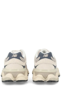 Cream-colored new balance unisex sneaker with navy blue accents and a chunky textured sole in grey style