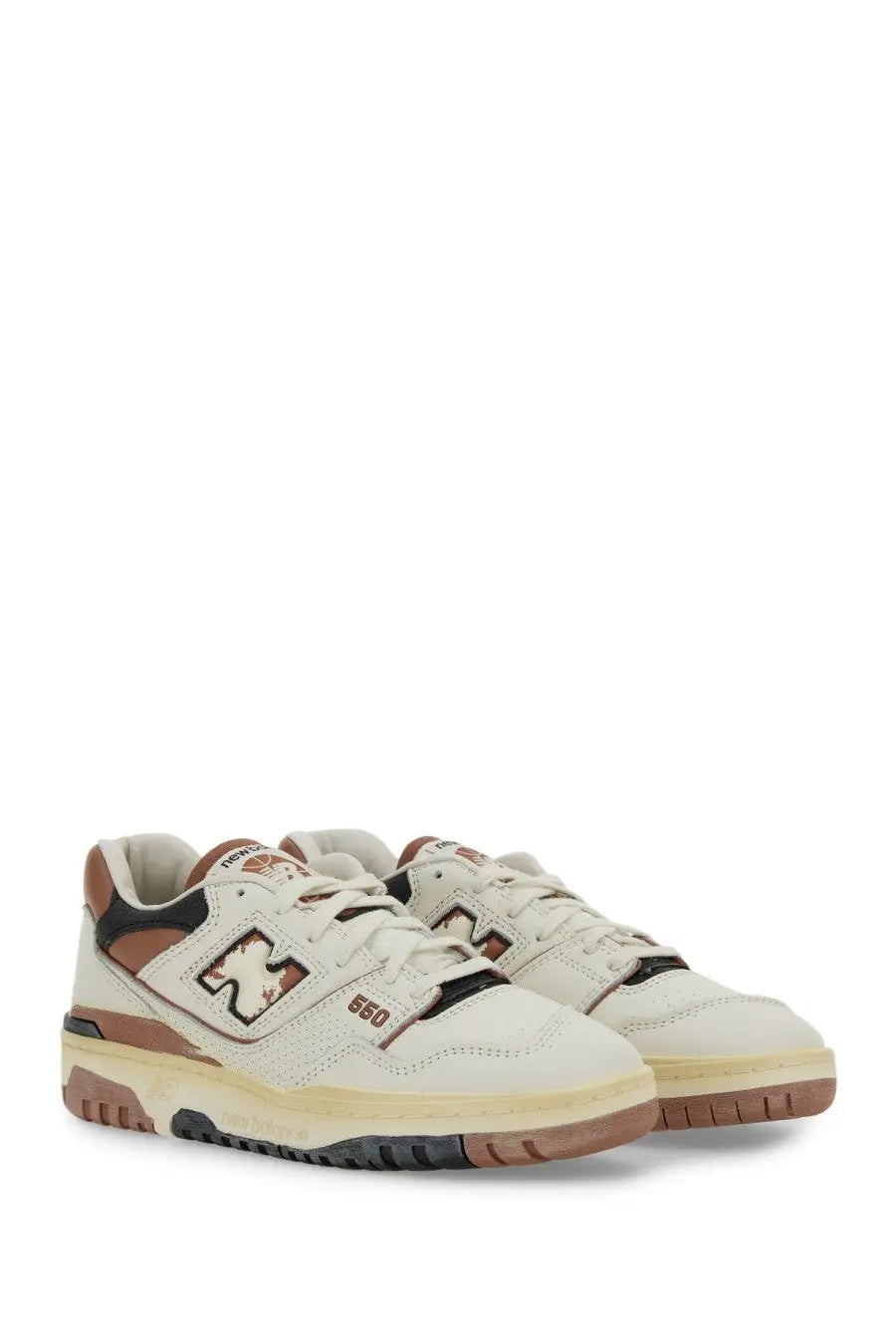 Cream-colored new balance 560 unisex sneaker with brown and black accents and classic retro design in white model