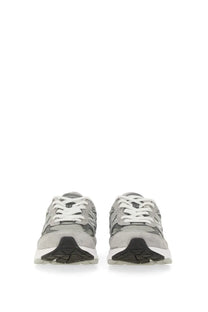 New balance women’s sneaker grey featuring gray and black 990v3 design with white laces and textured rubber sole