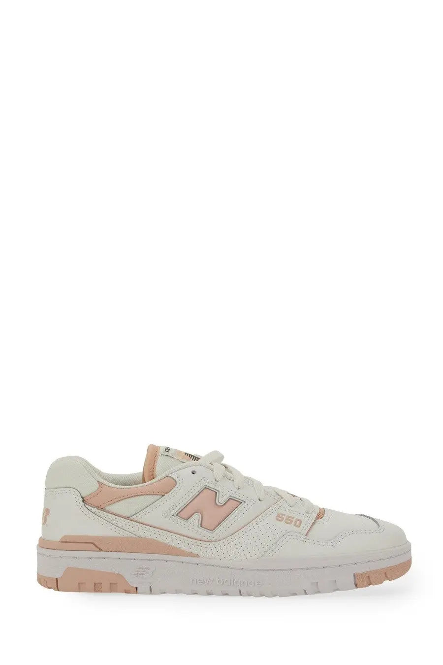 Cream-colored new balance women’s sneaker 550 with peach accents and perforated leather upper in white tone