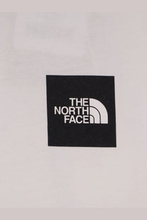 Black square patch with white the north face logo and half dome symbol on the north face mens white cotton shirt