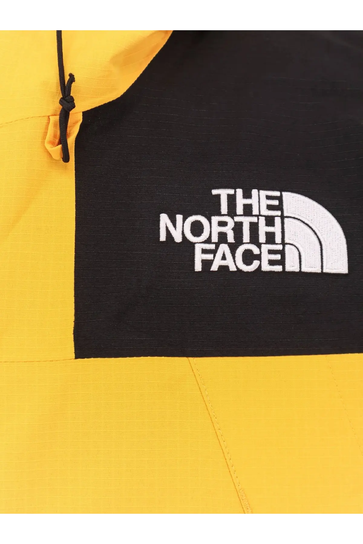 The north face men’s dryvent mono nylon windbreaker jacket in yellow and black with white embroidered logo on chest