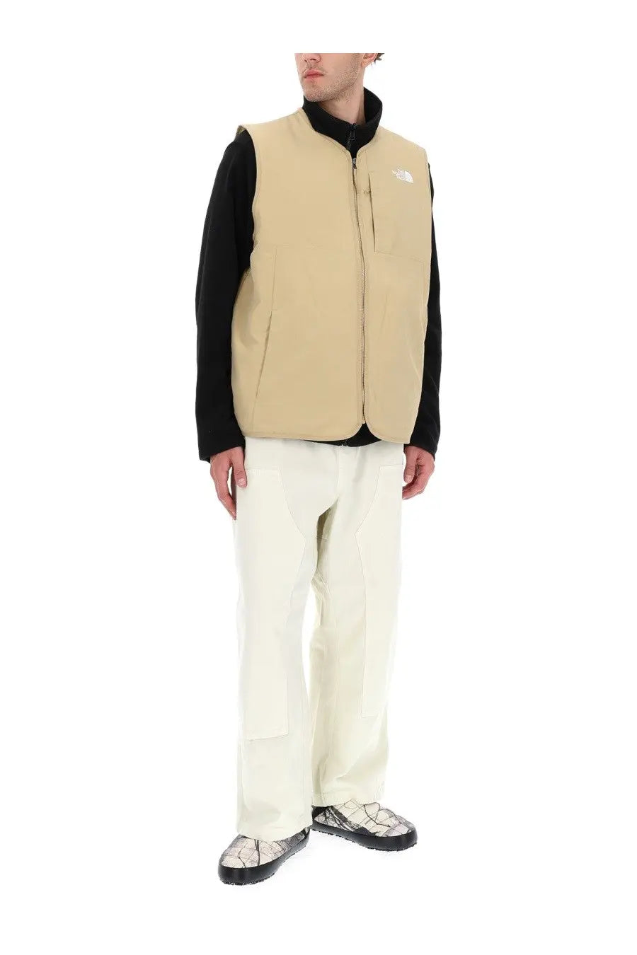 The North Face men’s Ilti liner vest in beige features a black collar and front zipper for lightweight warmth