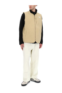 The North Face men’s Ilti liner vest in beige features a black collar and front zipper for lightweight warmth