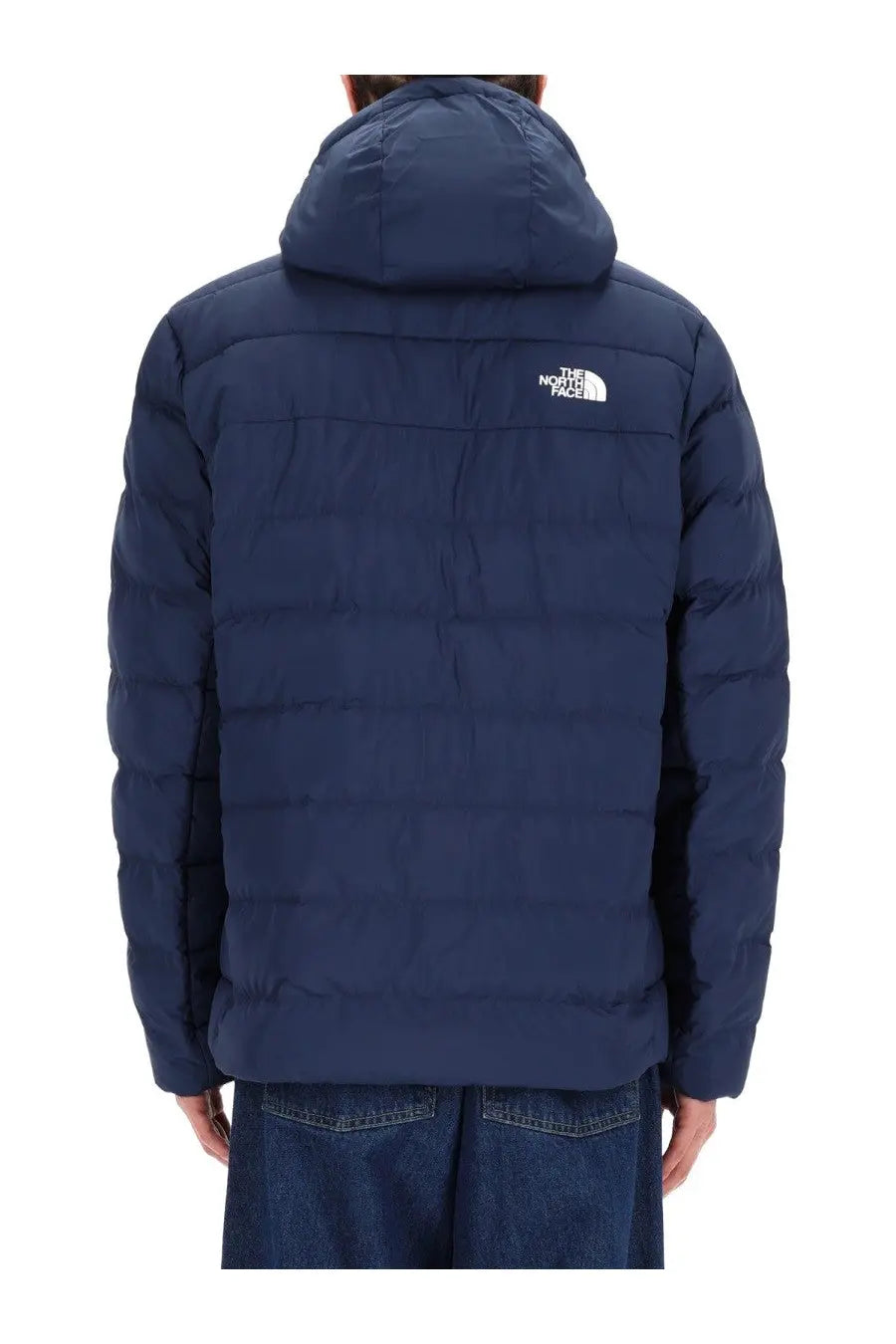 The North Face men’s dark blue quilted puffer jacket with hood shown from the back featuring the logo on upper back