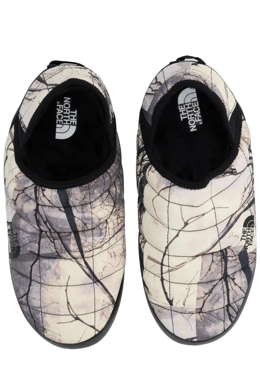 The north face men’s mule shoe thermoball grey slip-on features a quilted white and black tree branch pattern with black rubber soles