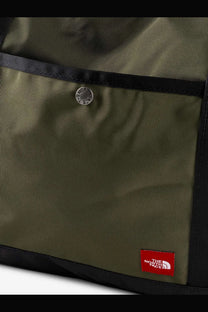 The North Face men’s nylon shoulder bag in beige with olive green canvas, black trim, and a silver snap button