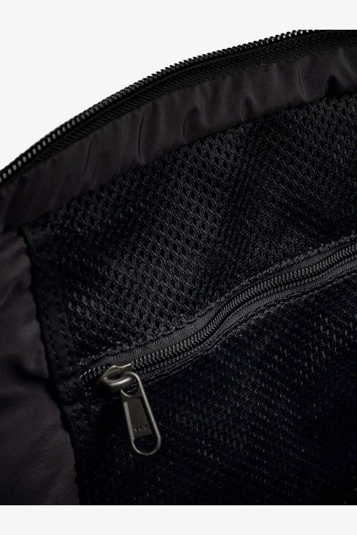 The North Face men’s black nylon shoulder bag interior with black mesh lining zipper and pull tab visible