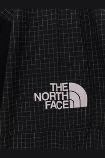 The north face men’s relaxed fit jacket in black features a black and white grid pattern with a white logo patch