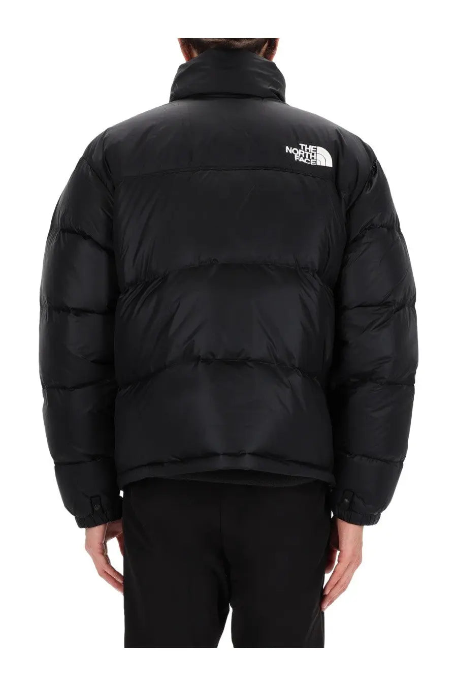 The back of a black the north face men’s retro nuptse puffer jacket with quilted design and white logo on the collar