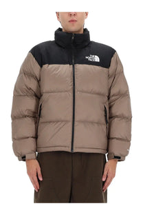 The north face men’s retro nuptse jacket in brown features a tan and black quilted puffer design for warmth