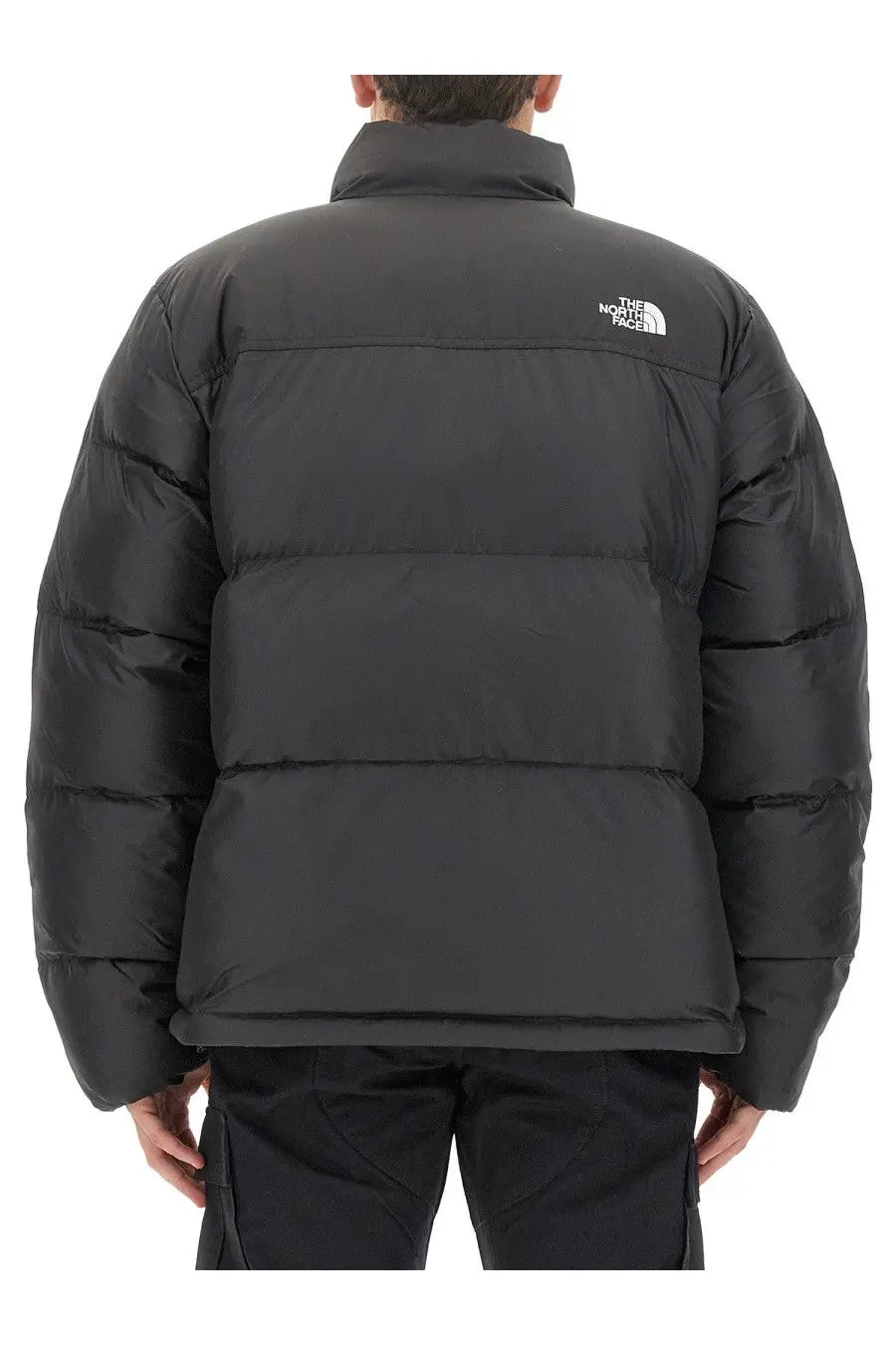 The back side of a black the north face men’s saikuru puffer jacket with horizontal stitching and a white logo